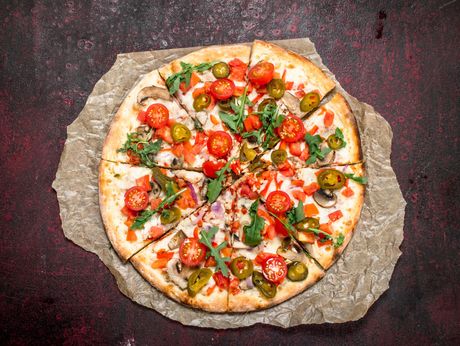 fresh pizza with tomatoes and greens