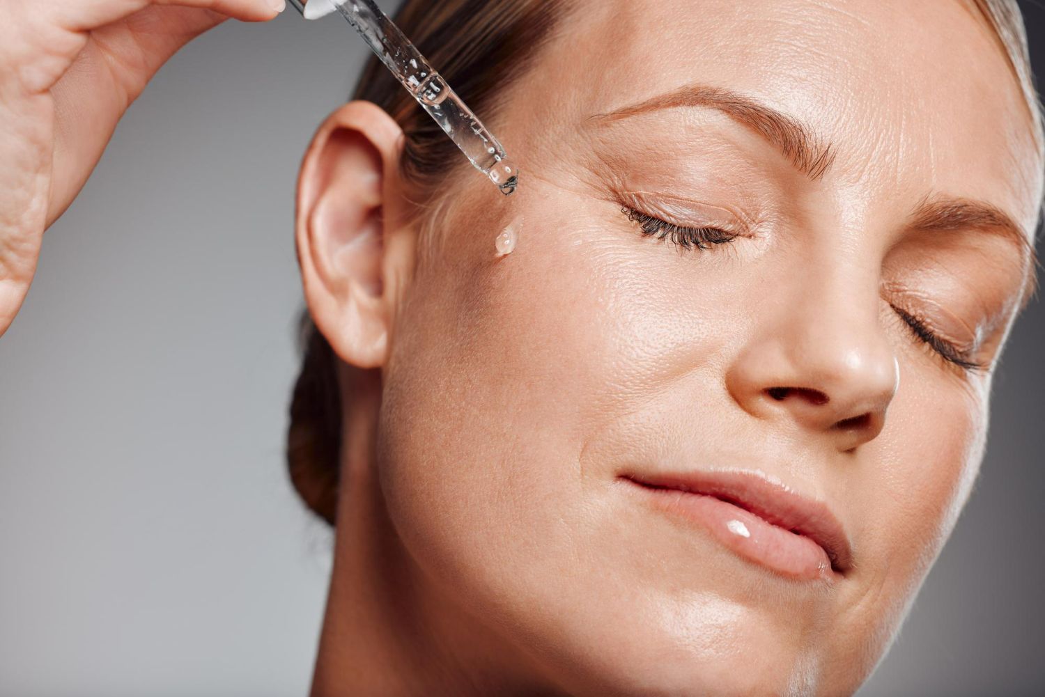 Close-up of a woman receiving a facial serum injection near her eye