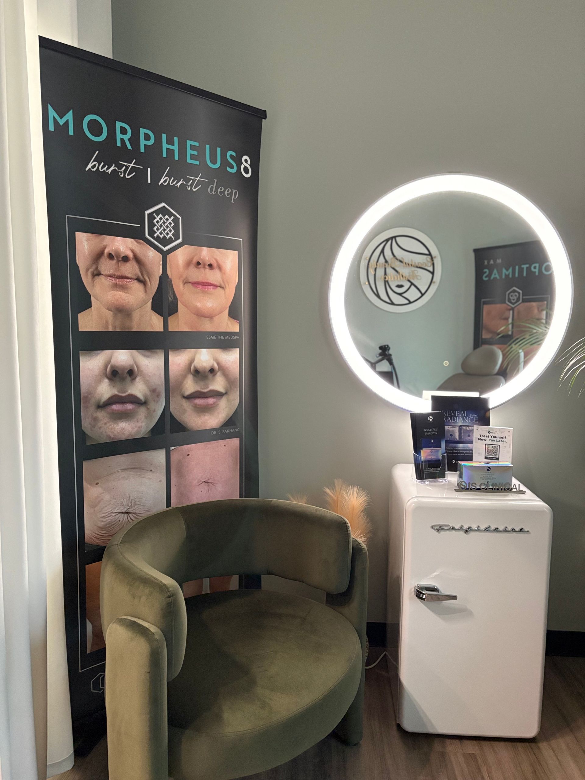 Morpheus8 clinic display with olive chair, ring light mirror, and branded signs in a waiting area