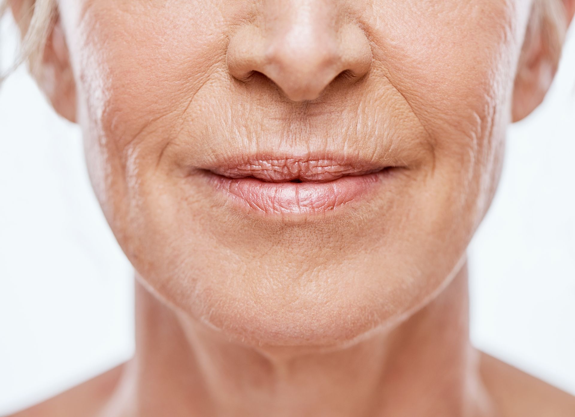Close-up of a smiling mouth and chin on a white background