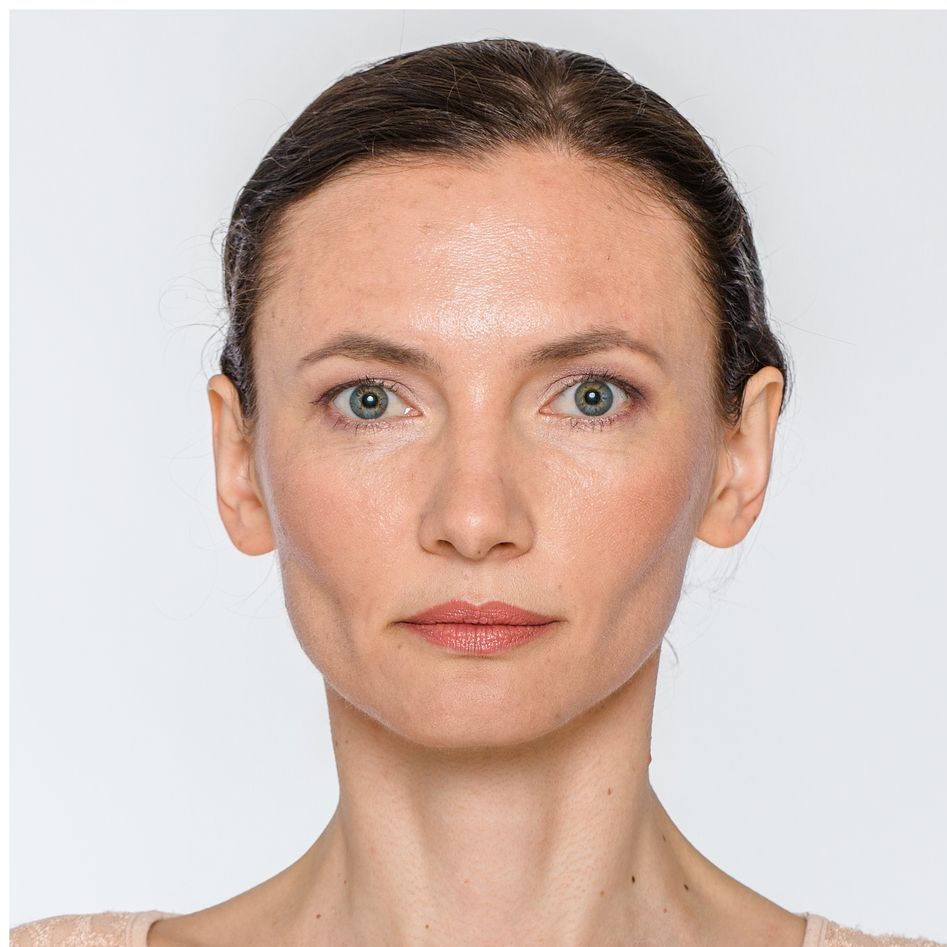 Head-and-shoulders portrait of a person with dark hair against a light background, looking directly at the camera