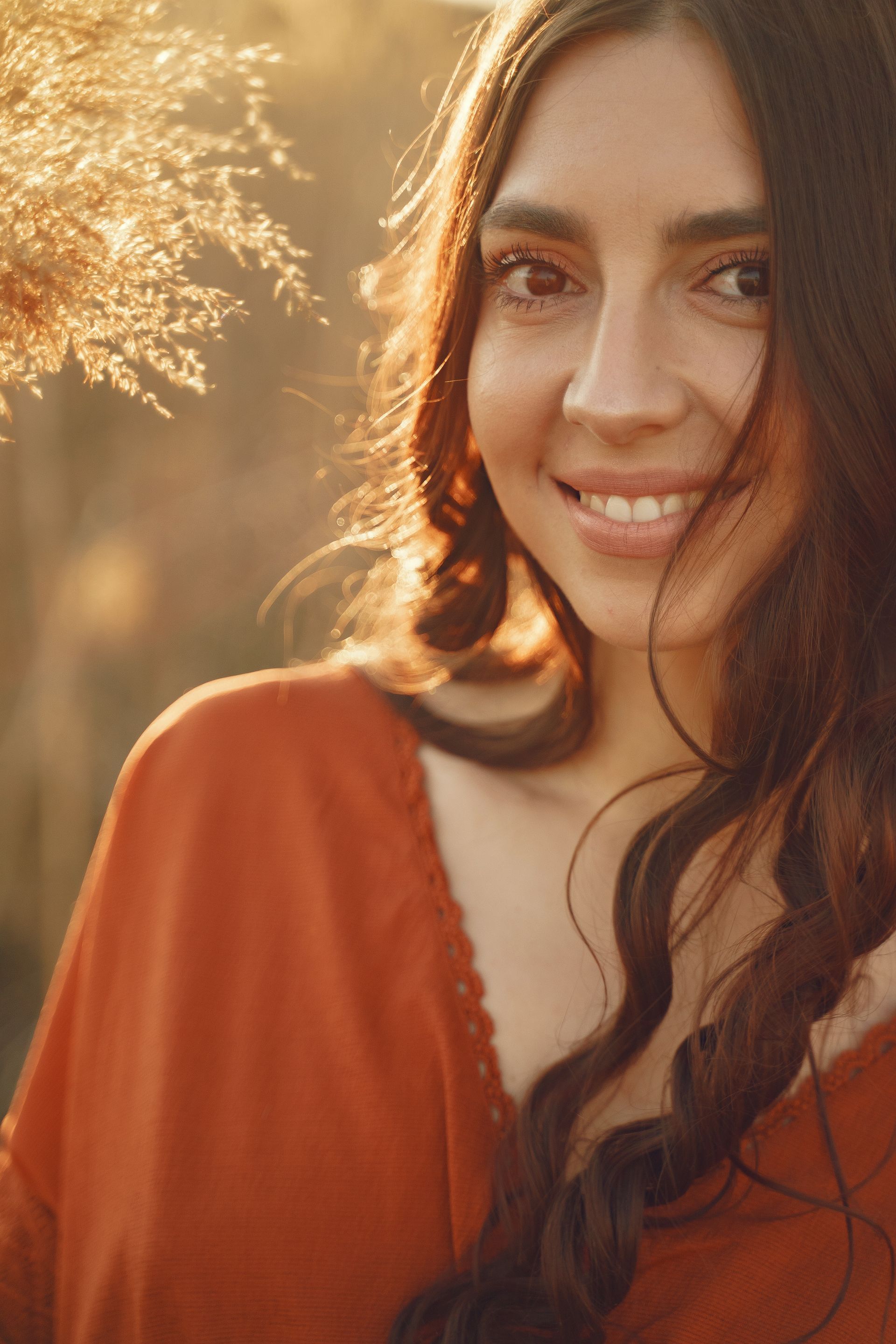 A woman in a red dress is smiling and looking at the camera.