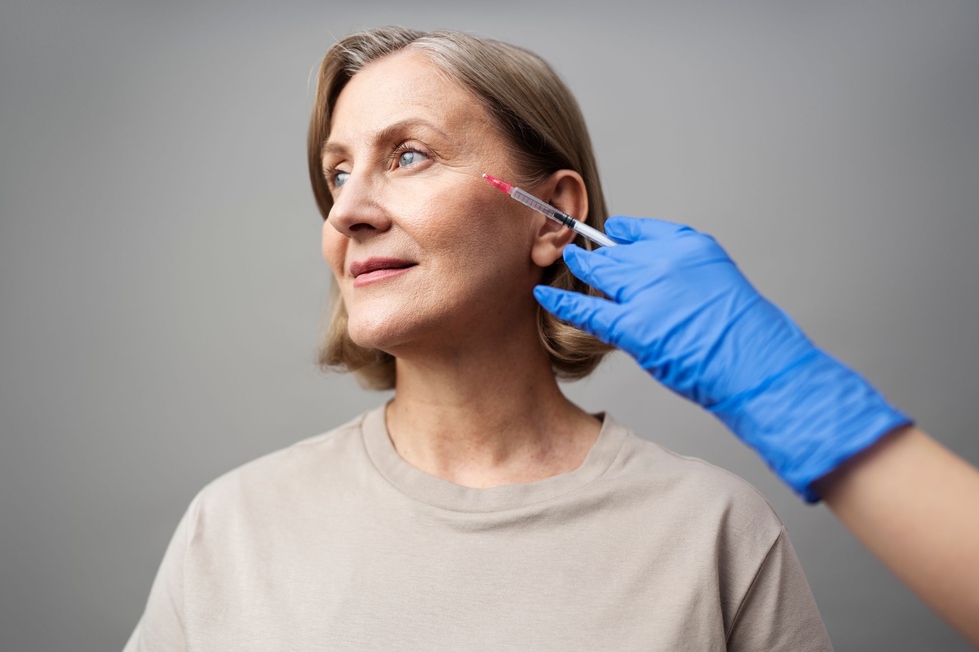 A woman is getting a botox injection in her face.