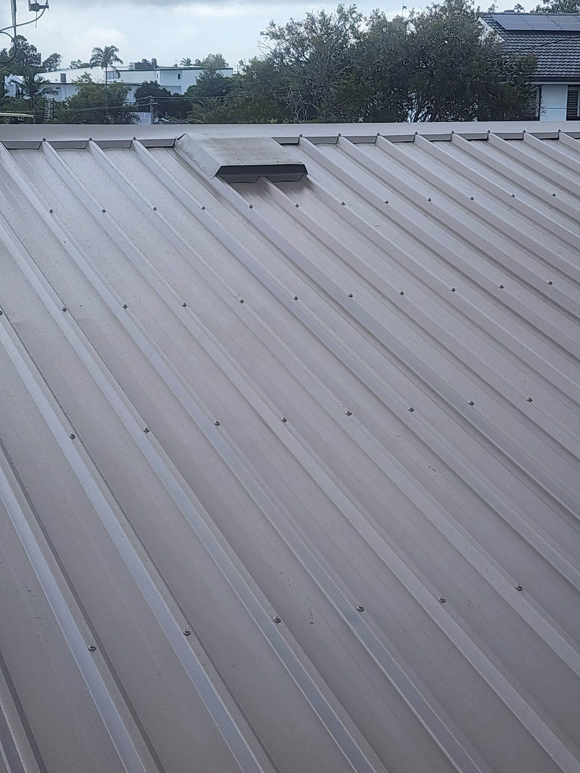 A Roof With a Red Car Parked in the Background — Vent Wise in Twin Waters, QLD