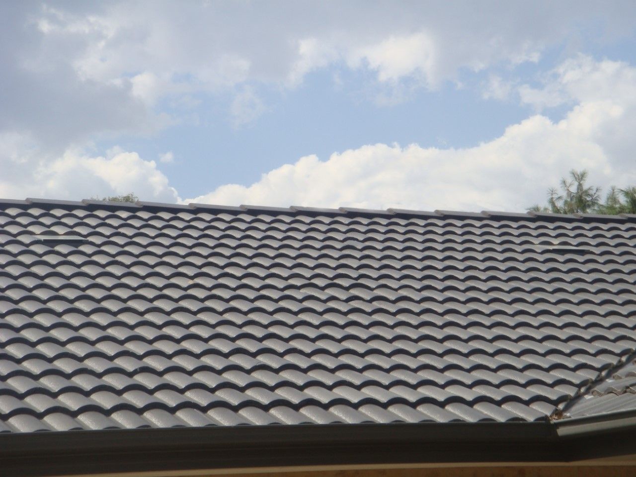 A Brick House With a Black Roof and a Lot of Windows — Vent Wise in Twin Waters, QLD