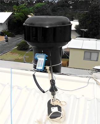 A Siren is Sitting on Top of a Roof Next to a House — Vent Wise in Twin Waters, QLD