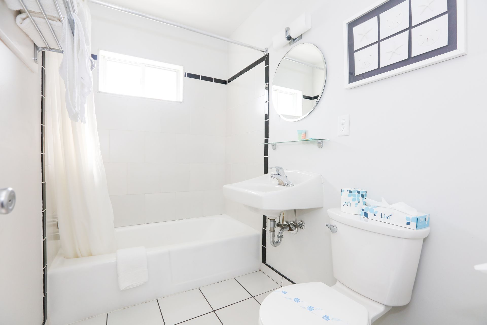 A bathroom with a toilet , sink , tub and mirror.