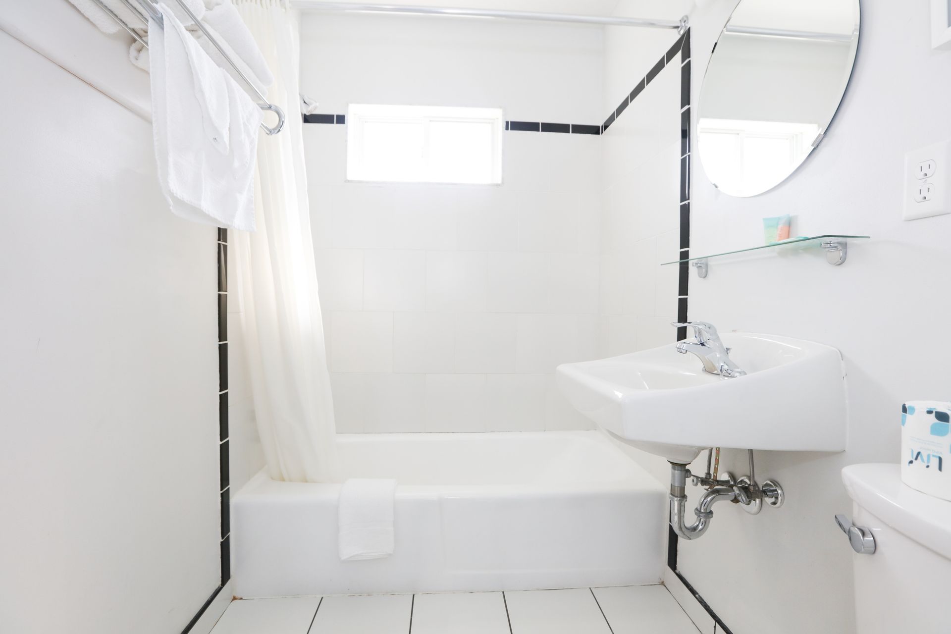 A bathroom with a sink , tub and mirror