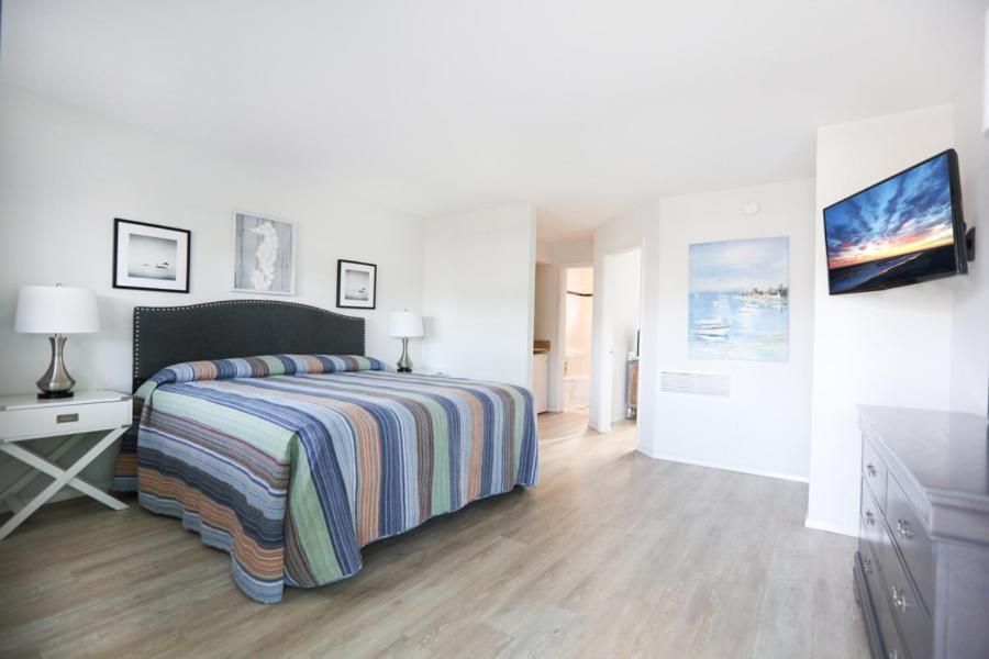 A bedroom with a king size bed and a flat screen tv.