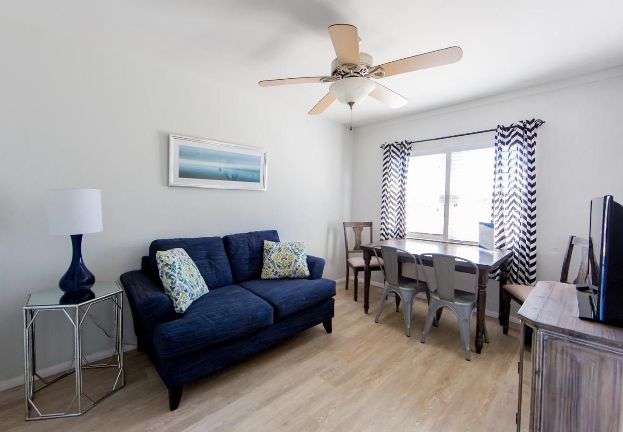 A living room with a blue couch and a ceiling fan