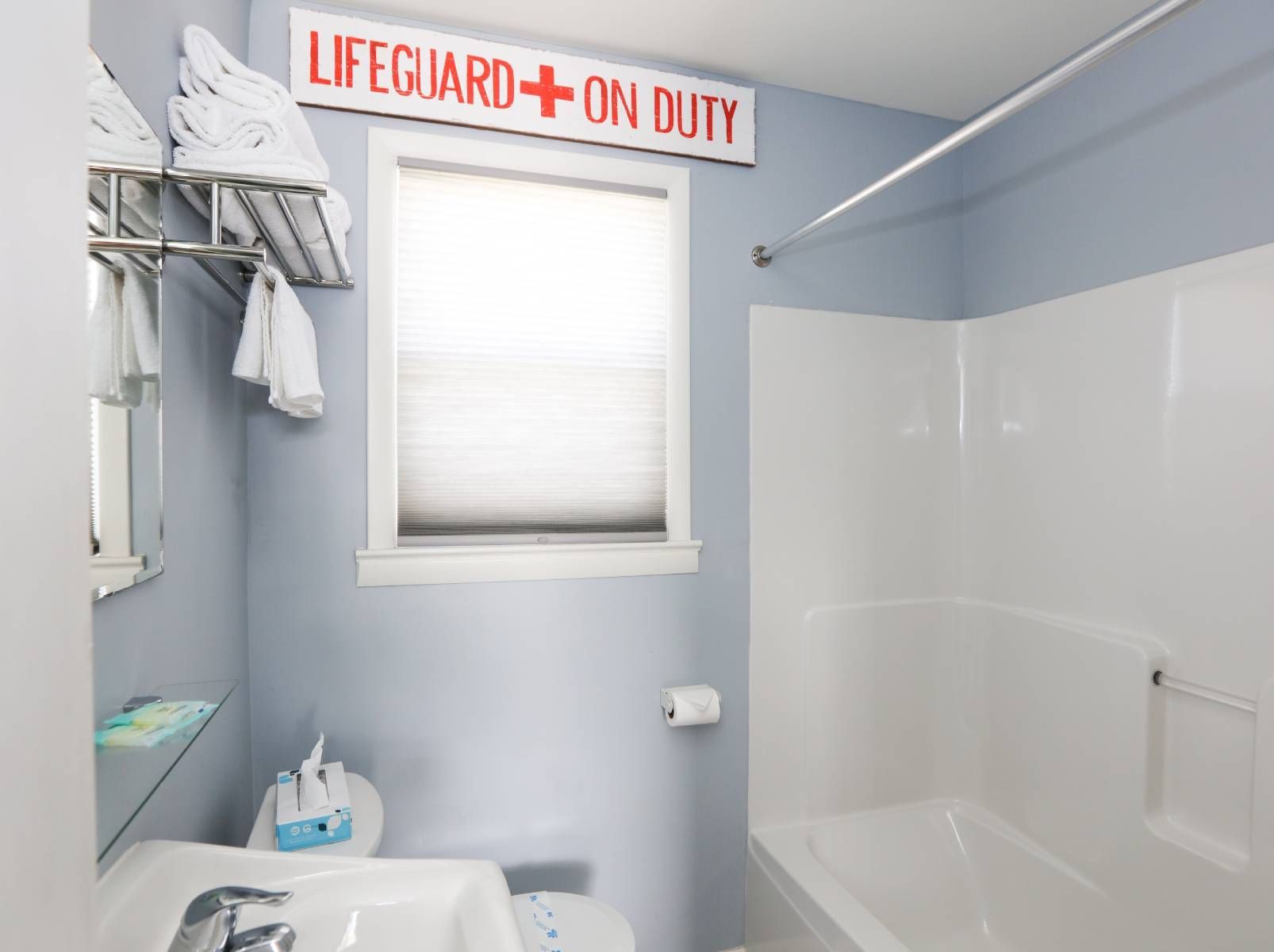 A bathroom with a sign that says lifeguard on duty