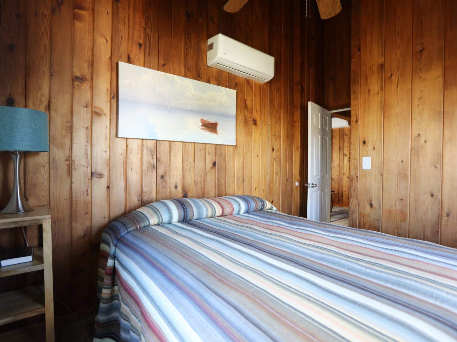 A bedroom with a bed and a ceiling fan