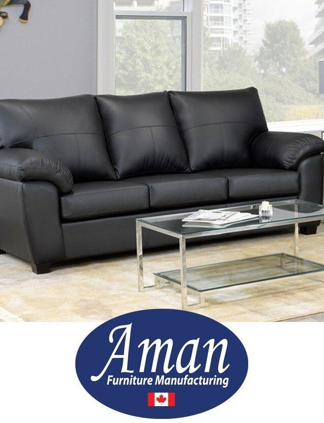 A living room with a black couch and a glass coffee table from aman furniture manufacturing