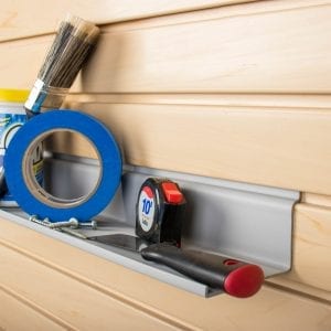A shelf with a tape measure and brushes on it