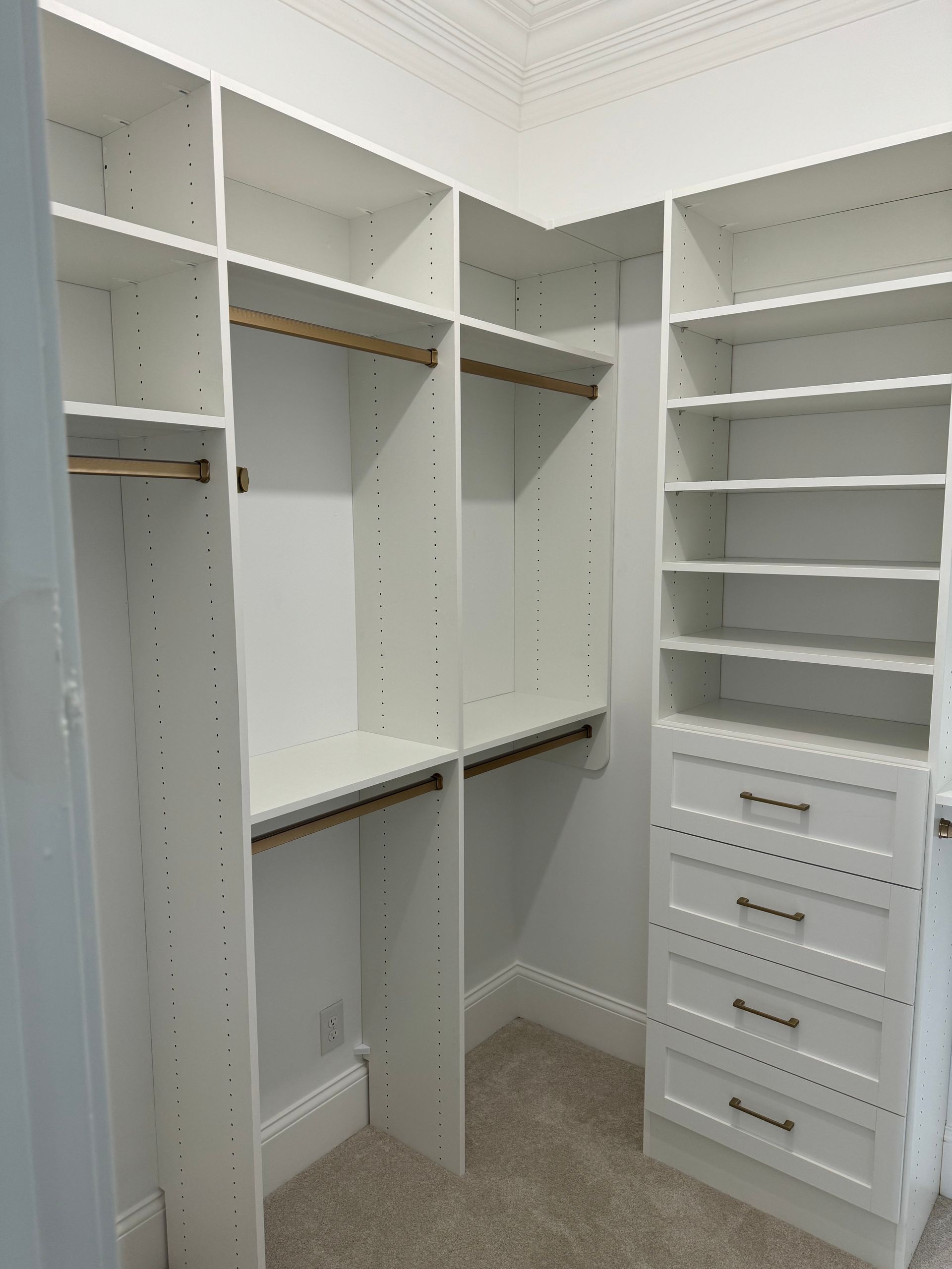 White custom closet with shelves, drawers, and hanging rods.