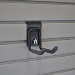 A black hook is hanging on a gray wall.