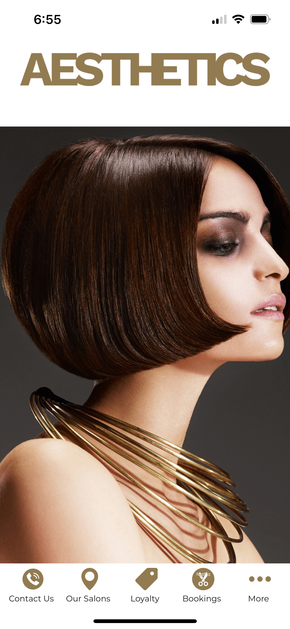 Woman with bob hairstyle and gold necklace, app interface on screen.