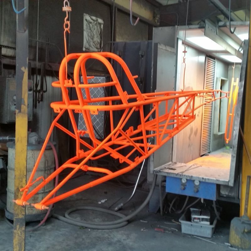 A Piece of Orange Metal is Hanging From the Ceiling