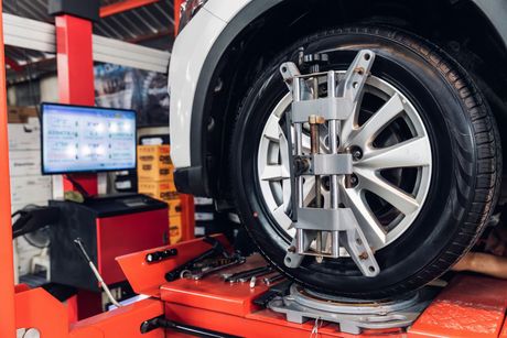 Mechanic aligning the wheel | Cain And Sons' Automotive