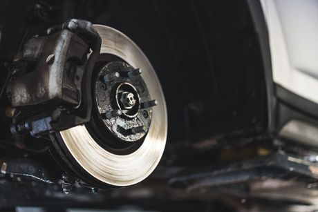 Mechanic working on brake disc | Cain And Sons' Automotive