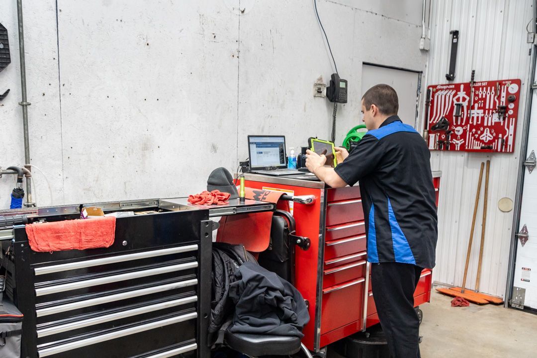 Mechanic working at a red tool chest in a garage workshop | Cain And Sons' Automotive