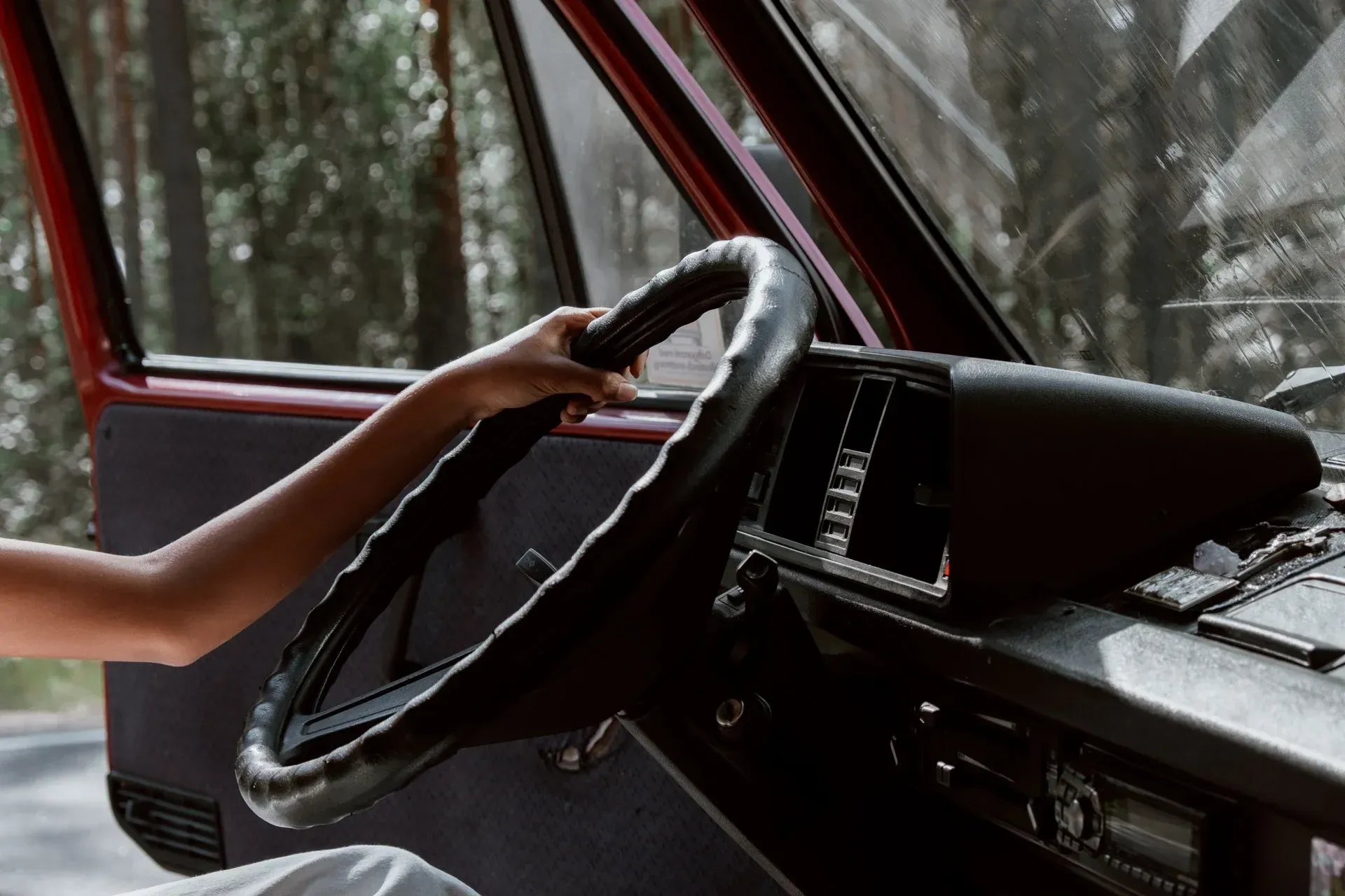 A person is holding the steering wheel of a car.