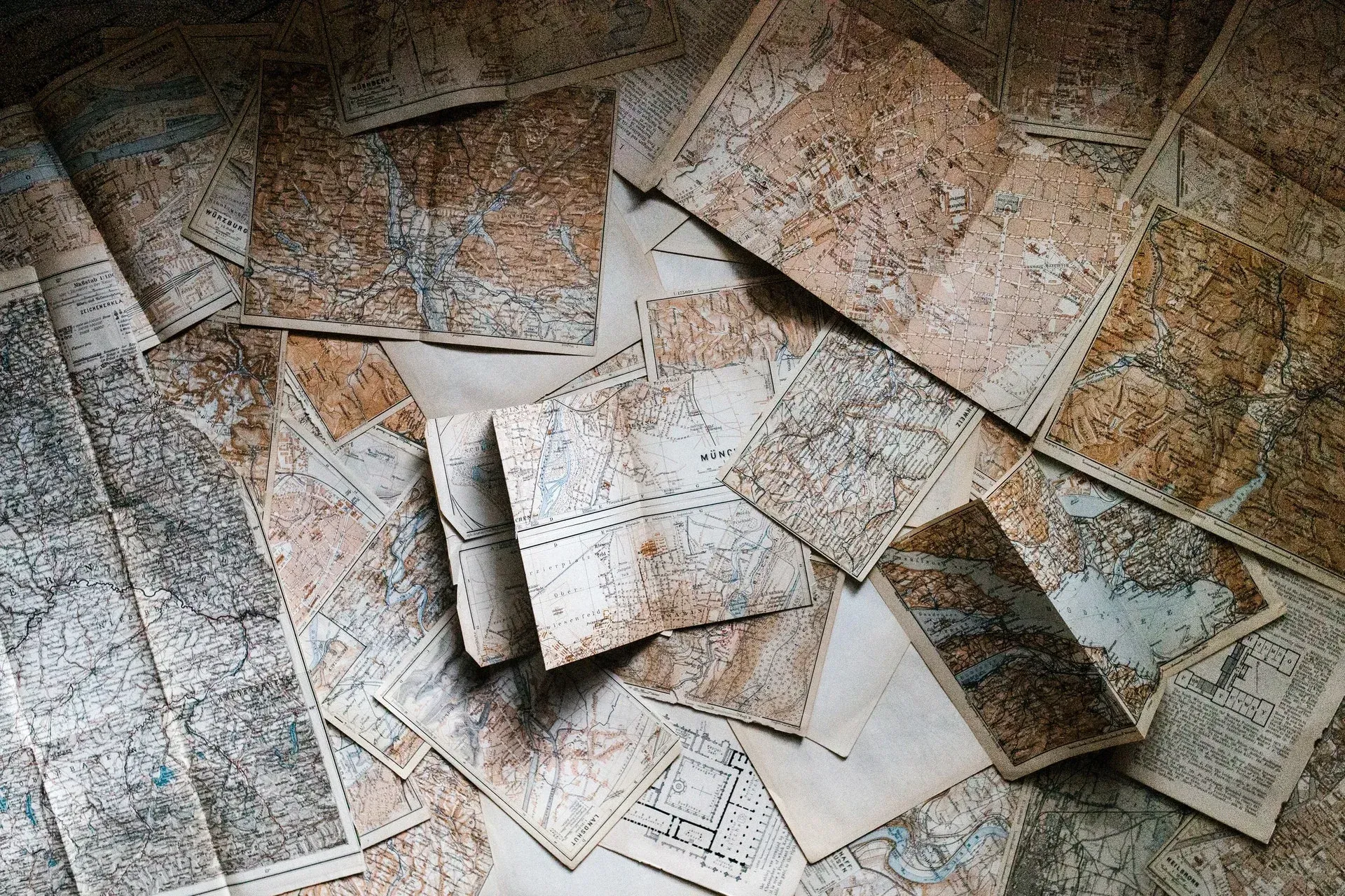 A pile of old maps are laying on the floor.