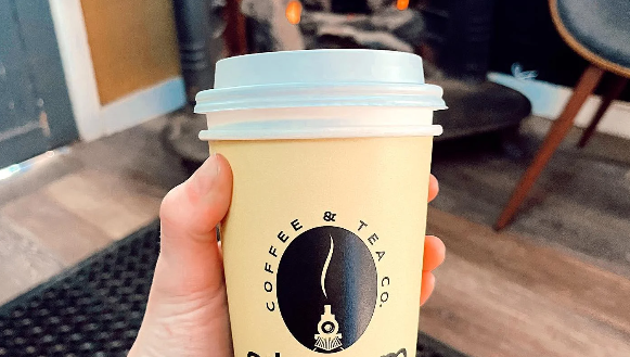 A person is holding a cup of coffee in their hand.