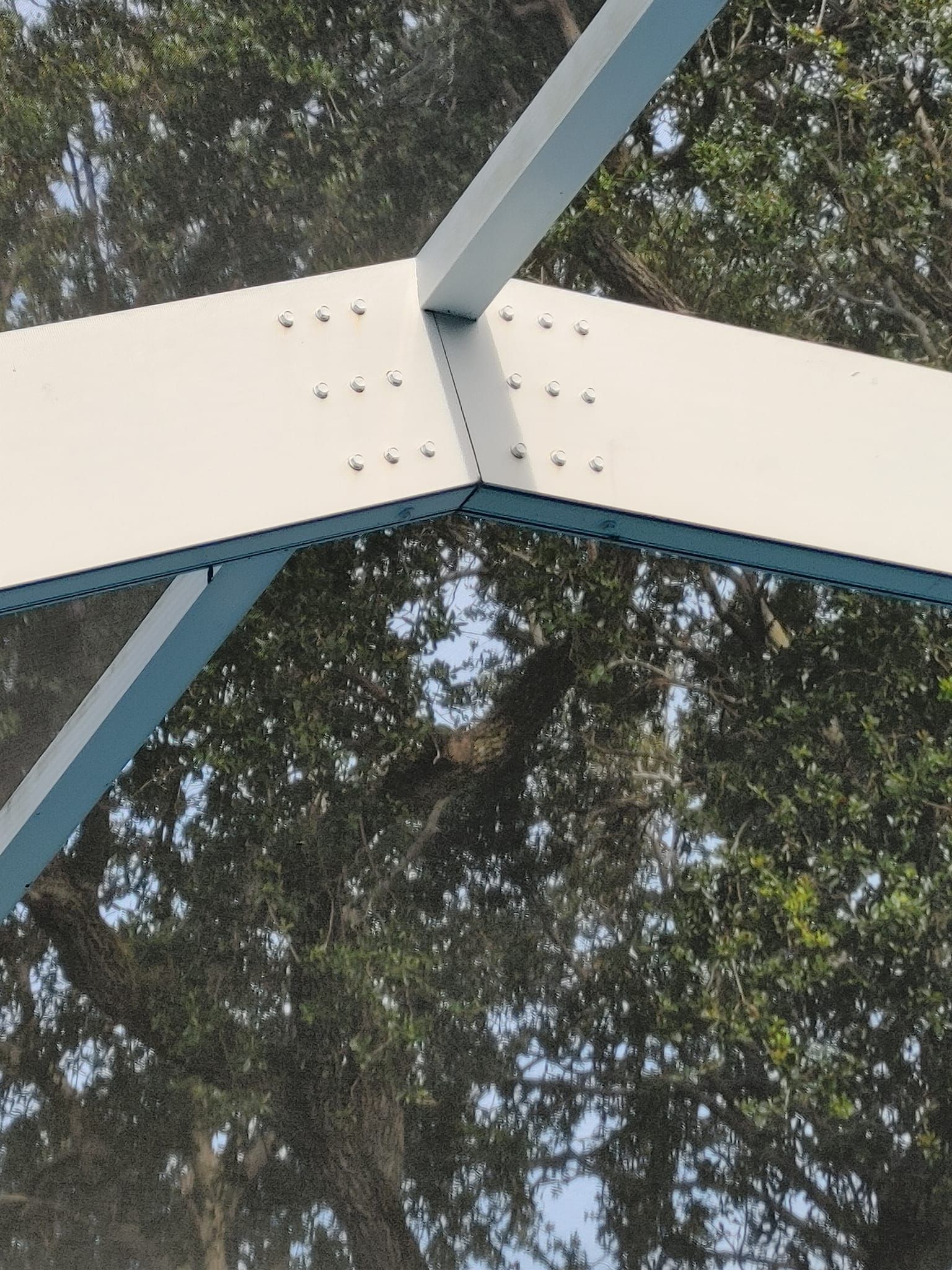 A close up of a metal structure with trees in the background