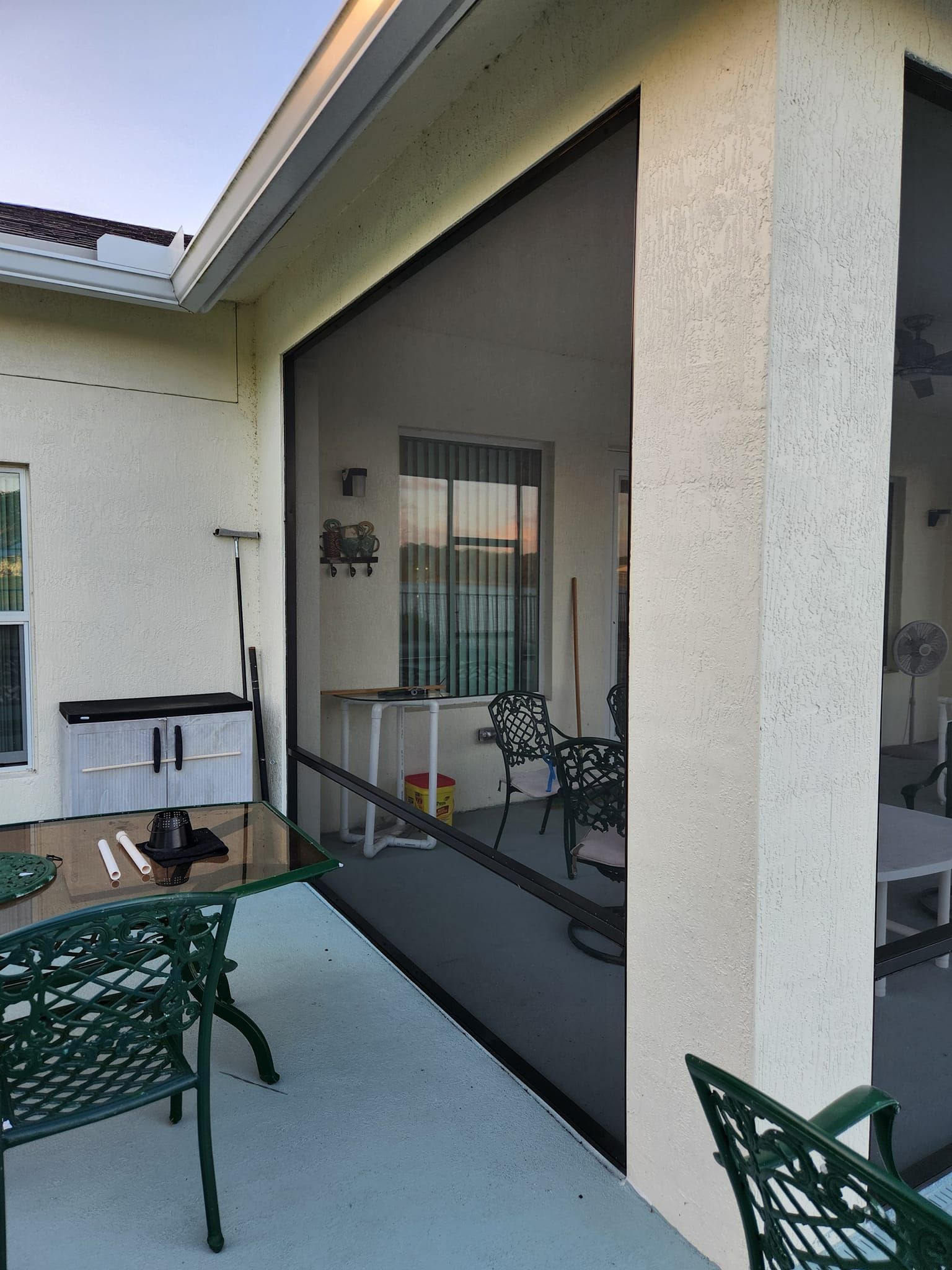 A screened in porch with a table and chairs