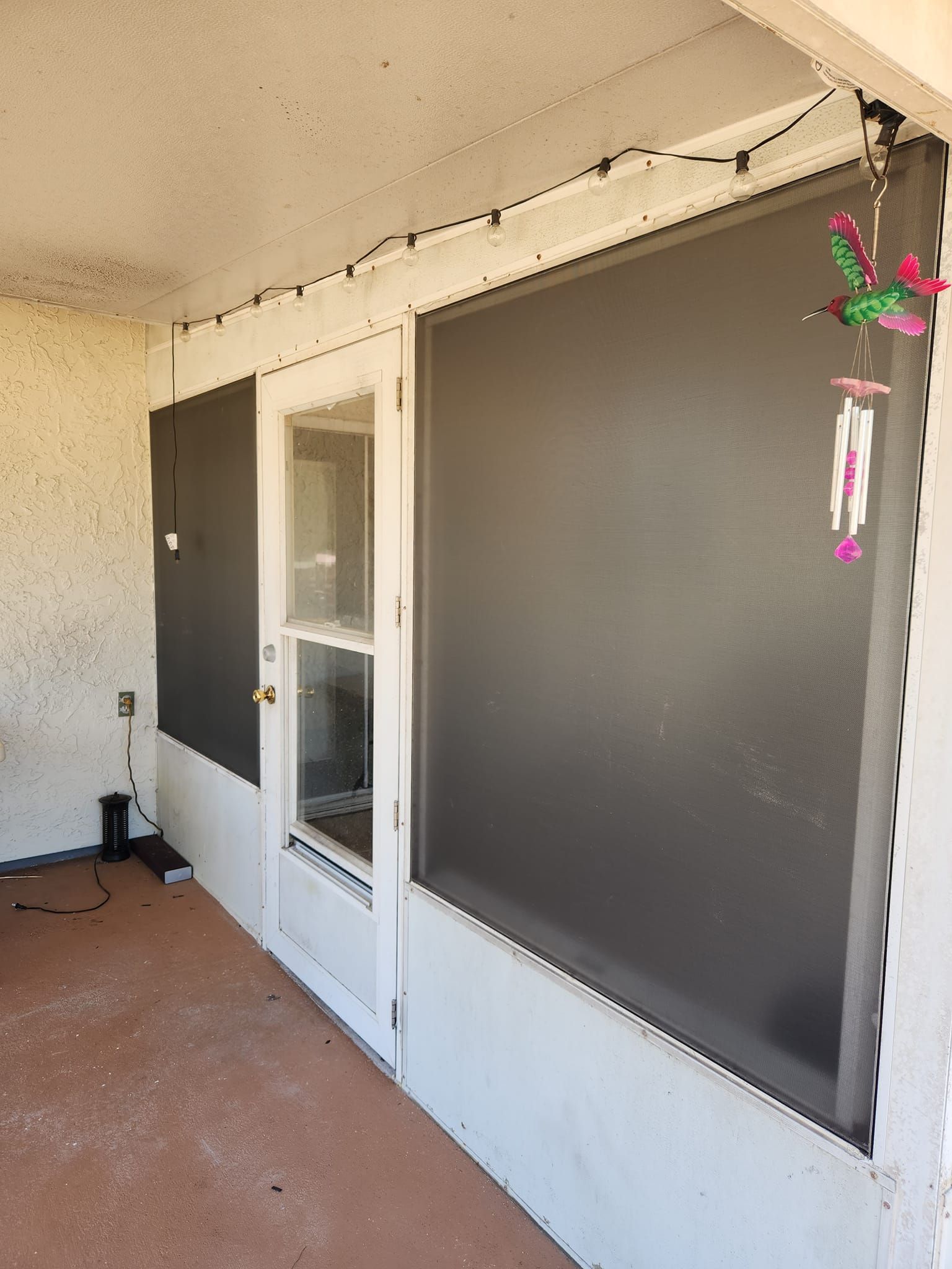 A screened in porch with a door and a window.