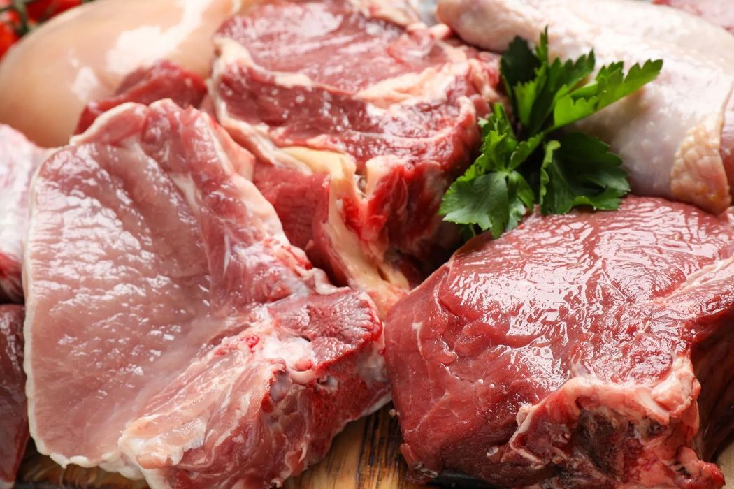 Tagli crudi di carne rossa e pollo con guarnizione di prezzemolo su un vassoio
