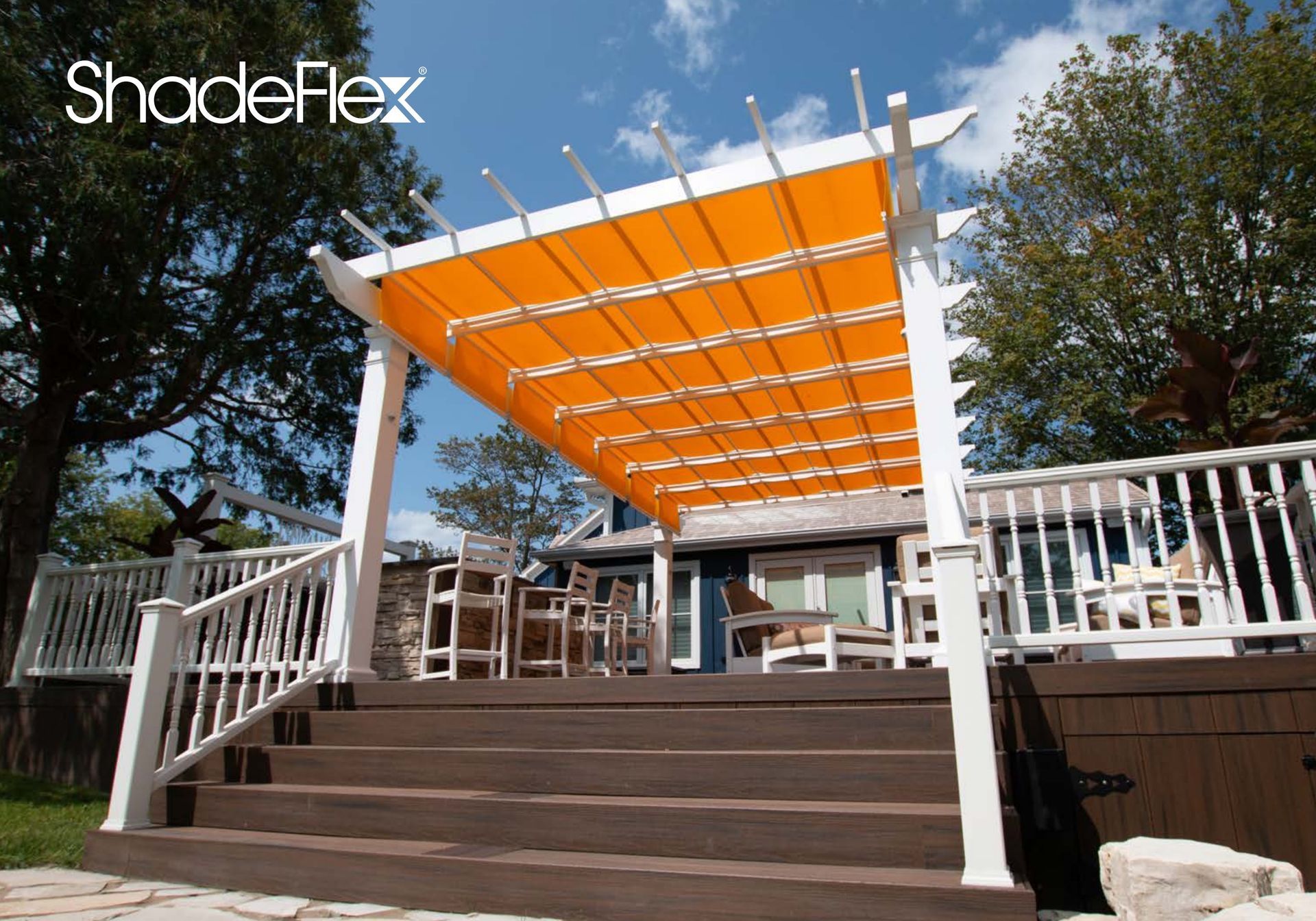 Modern patio with wooden pergola, lounge chairs, table, and tropical plants beside a pool