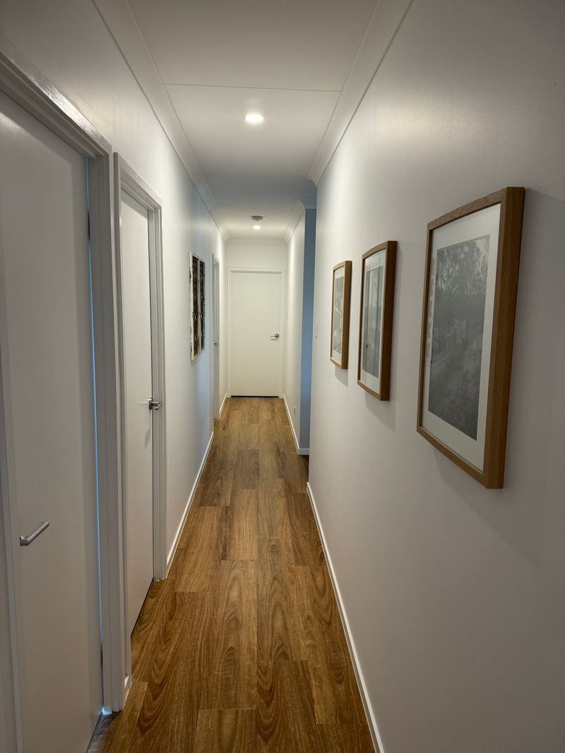 A long hallway with wooden floors and white walls