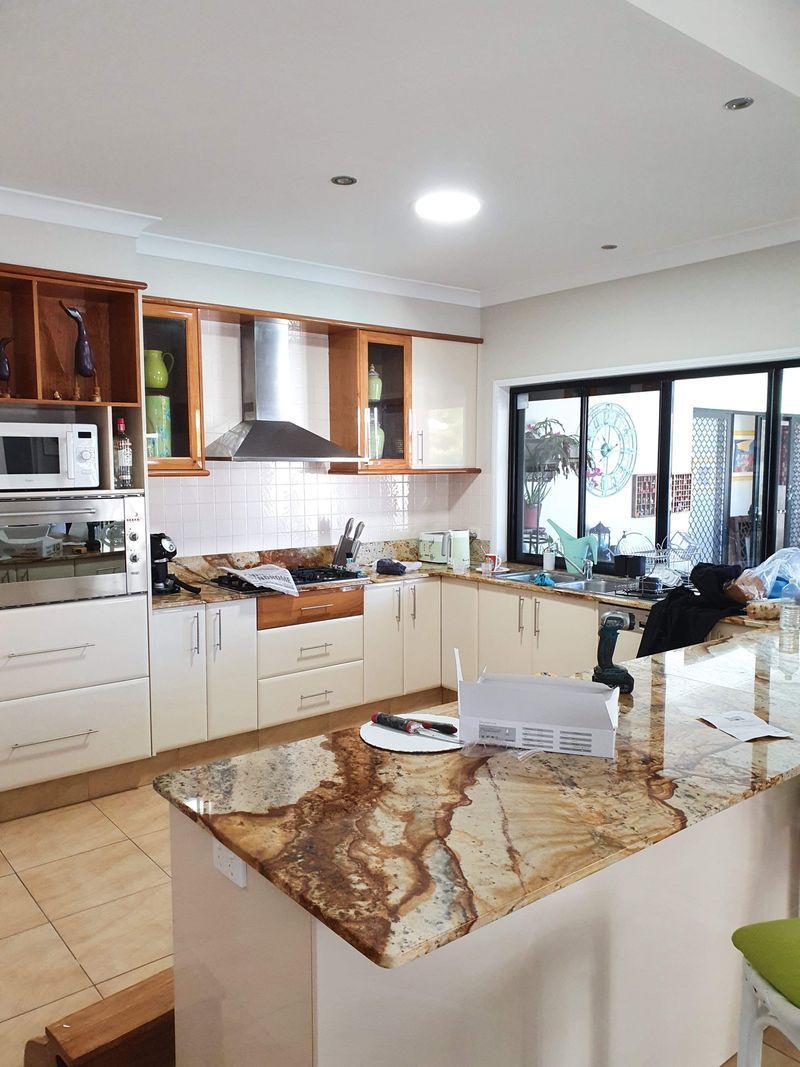 A kitchen with a granite counter top and white cabinets