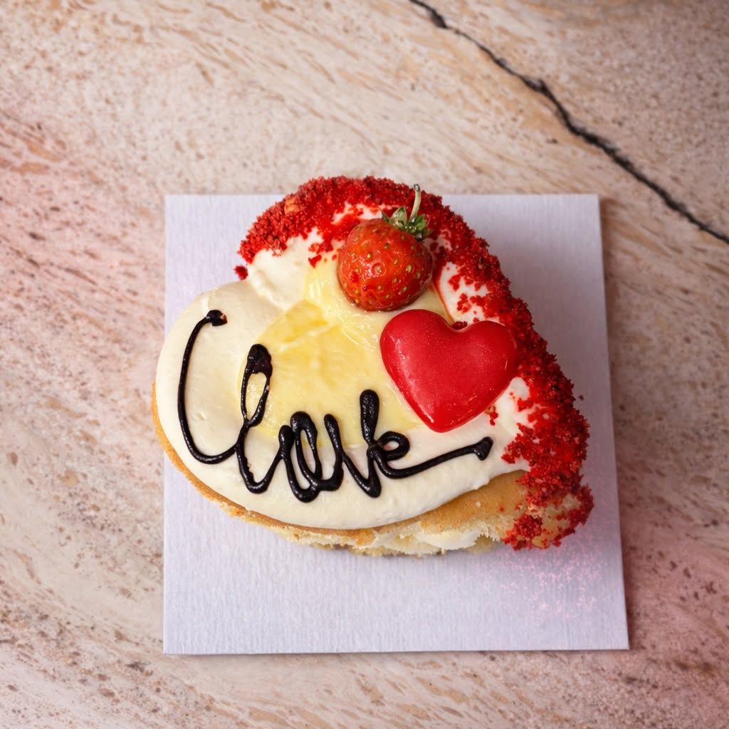 Pastry chef che decora dolci artigianali su banco da lavoro in acciaio