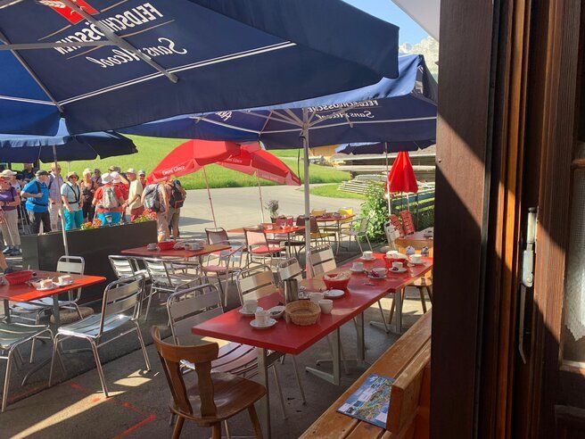 Eine Gruppe von Menschen hat sich unter Sonnenschirmen in einem Restaurant versammelt