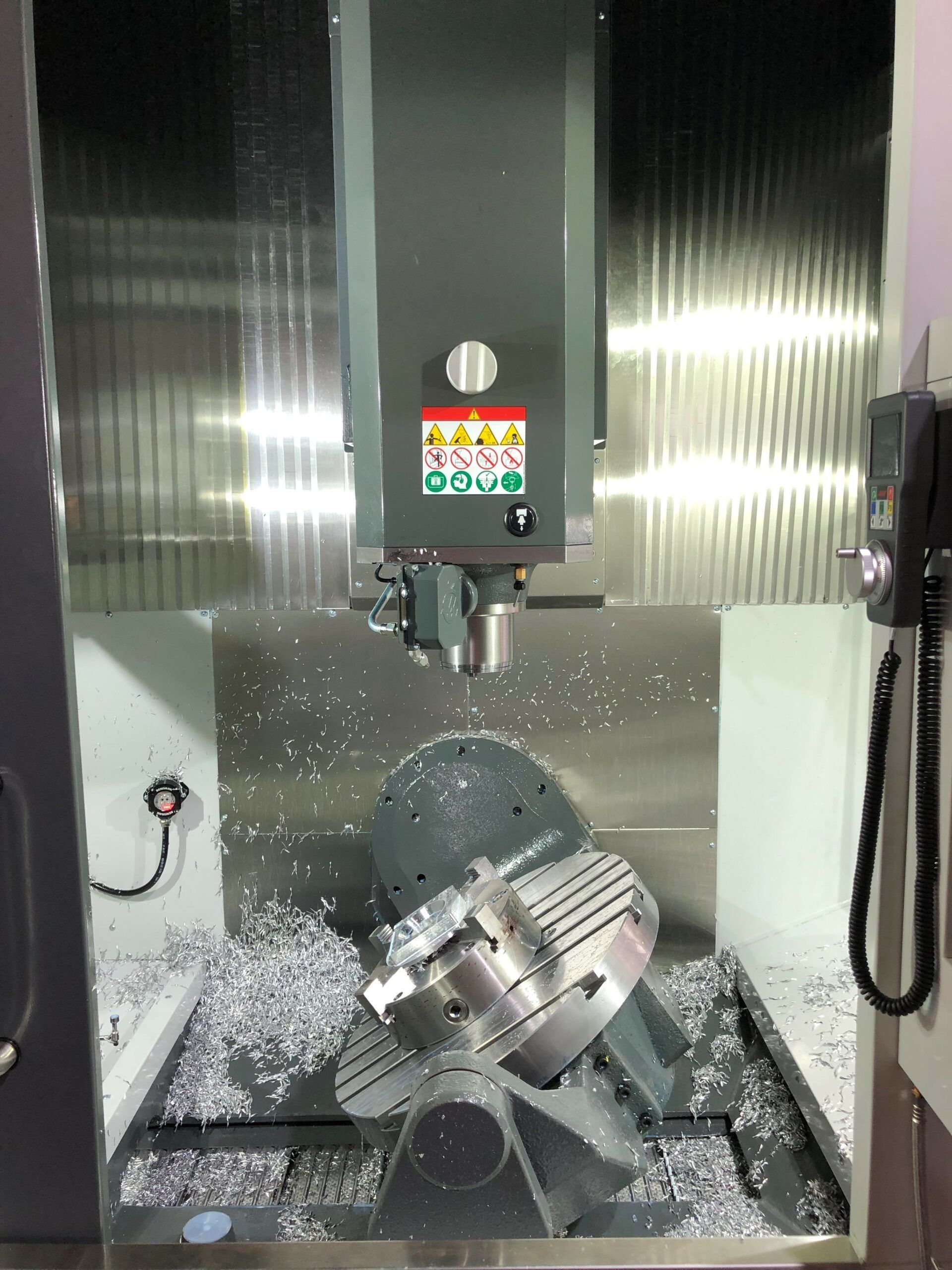 CNC-Fräsmaschine beim Bearbeiten von Metall, umgeben von Metallspänen.