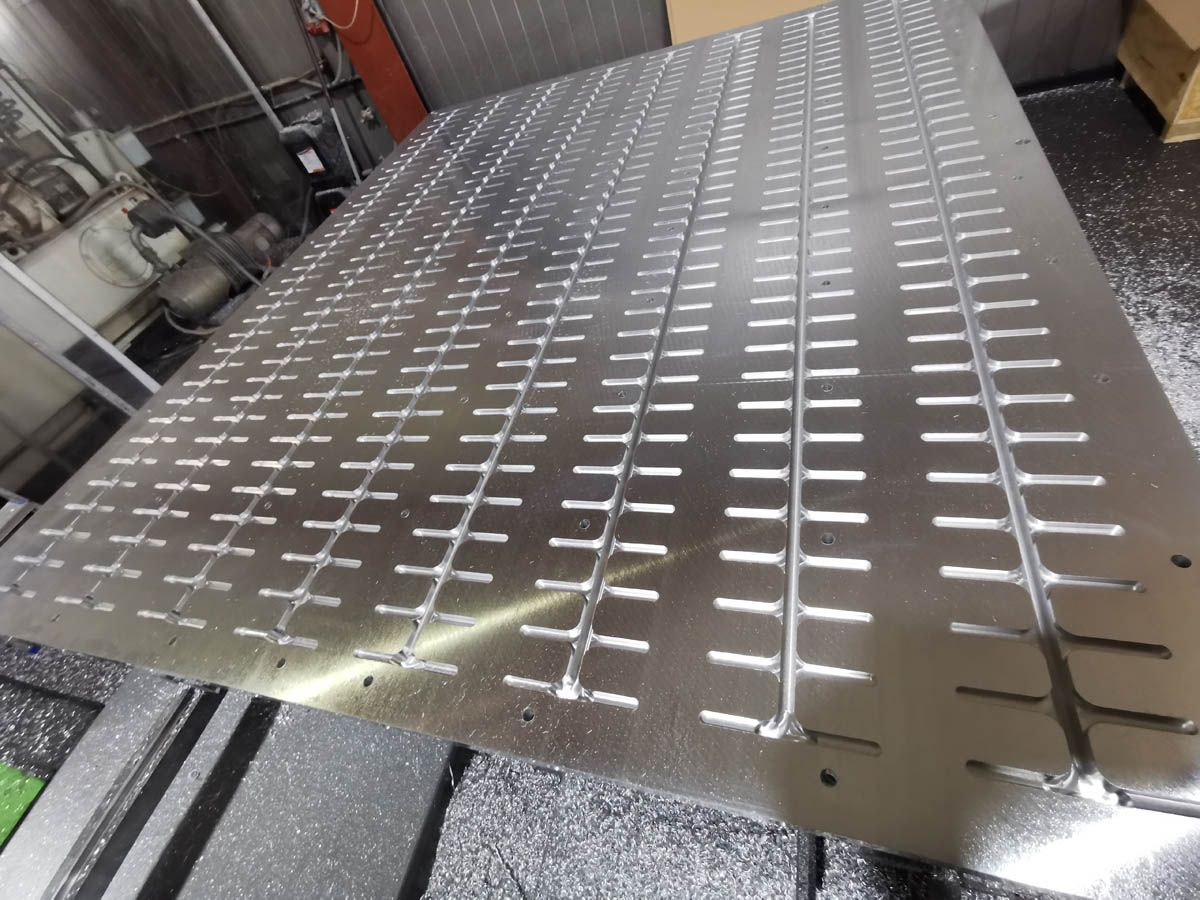 Großes Metallblech mit Reihen rechteckiger Ausschnitte, wahrscheinlich für industrielle Zwecke.