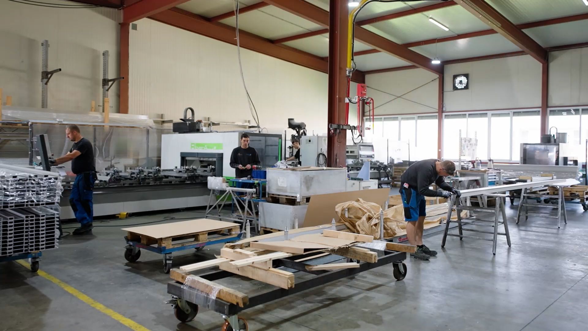 Arbeiter in einer Fabrik montieren Produkte mit Maschinen und Materialien.