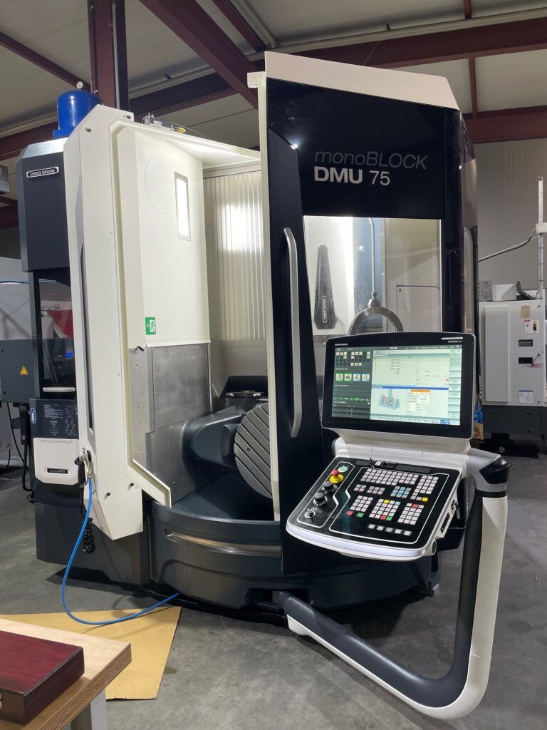 Eine DMG Mori DMU 75 Fräsmaschine. Schwarzweißaufnahme, mit Bedienfeld, in einer Werkstatt.