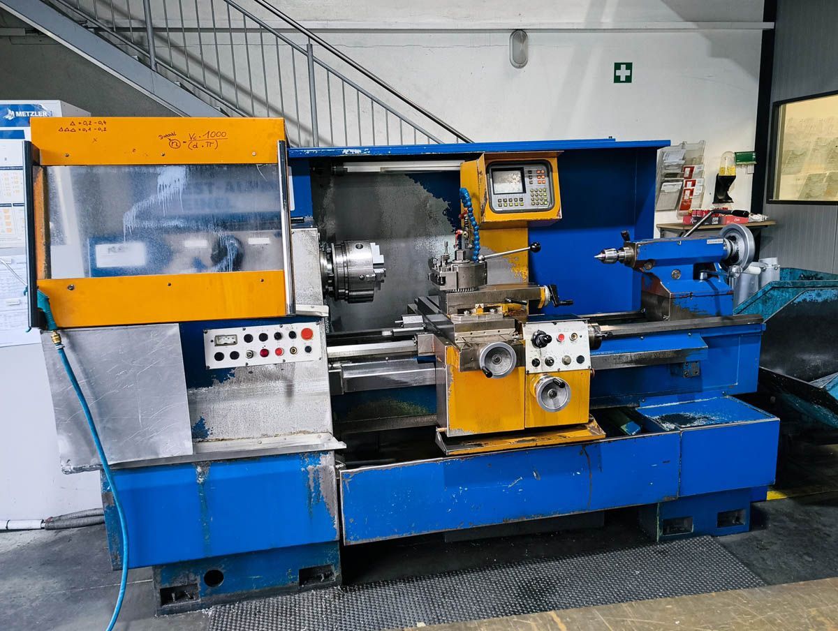 Blaue und gelbe Metalldrehmaschine in einer Werkstattumgebung.