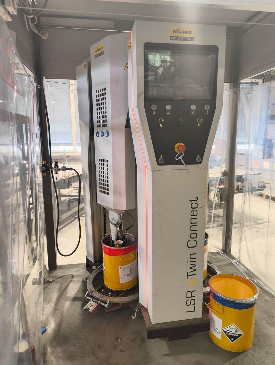 Eine Farbmischmaschine, LBA Twin Connect, mit zwei gelben Farbeimern in einer industriellen Umgebung.