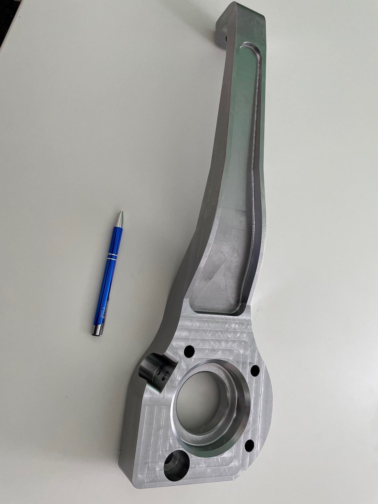 Maschinenteil aus silbernem Metall mit einem Stift als Größenvergleich.