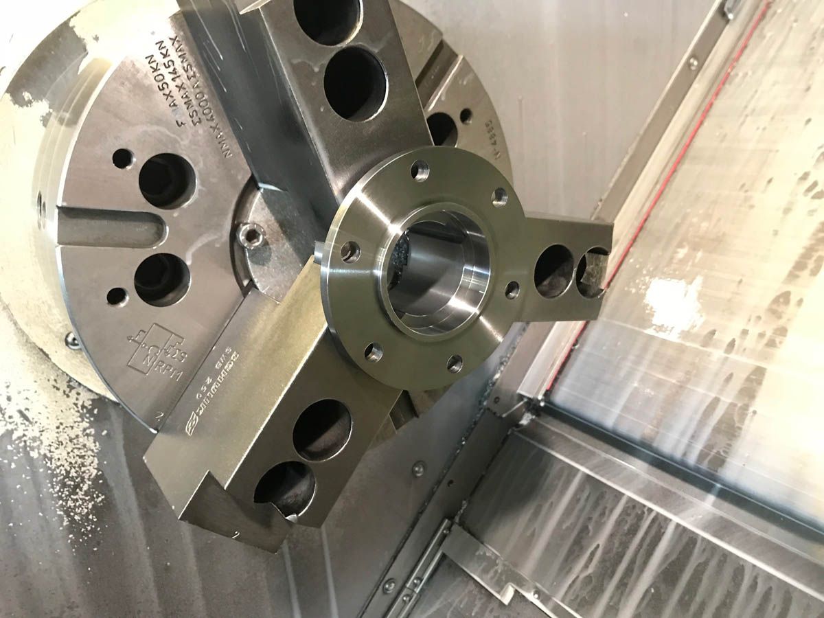 Ein Metallteil ist in einem Dreibackenfutter auf einer CNC-Maschine eingespannt
