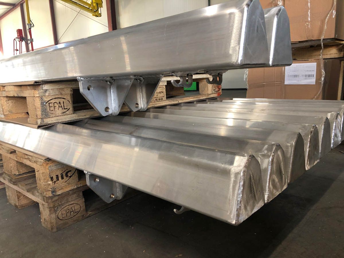 Aluminium-Metallteile auf Paletten in einer Lagerhalle.