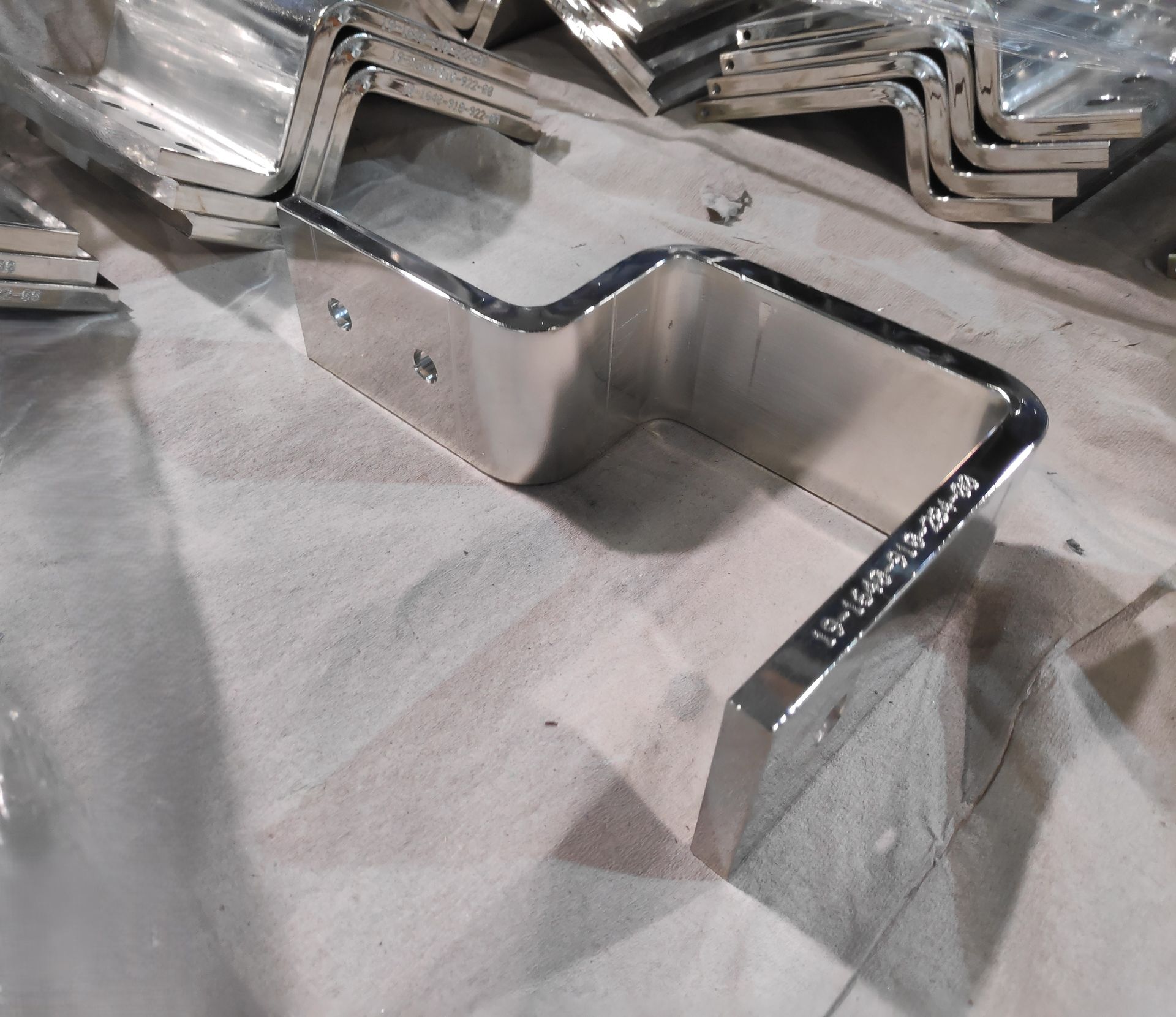 Eine U-förmige Metallhalterung, die auf einer Oberfläche neben anderen ähnlichen Halterungen steht.