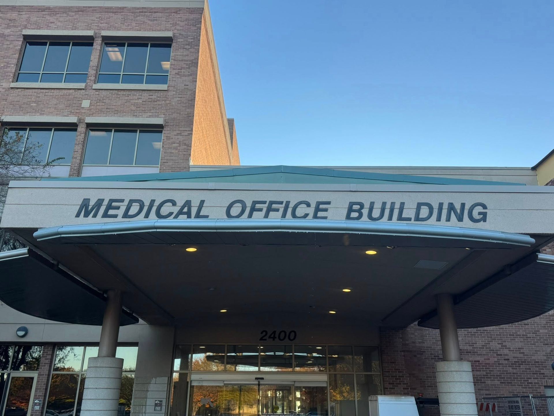 Exterior view of a multi-story brick medical office building entrance with a covered driveway and the number 2480.
