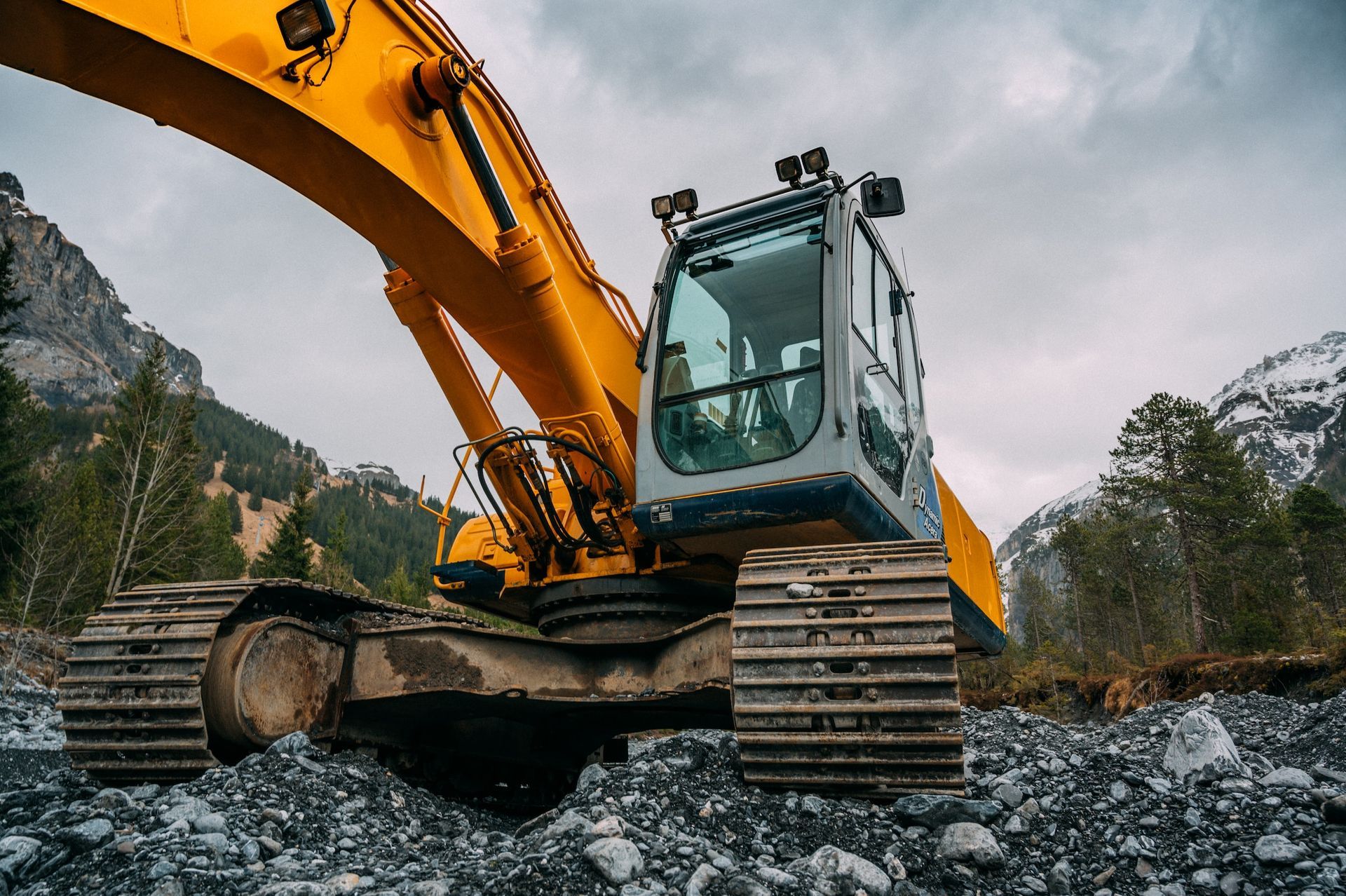 Yellow And Green Excavator On Rocky Ground