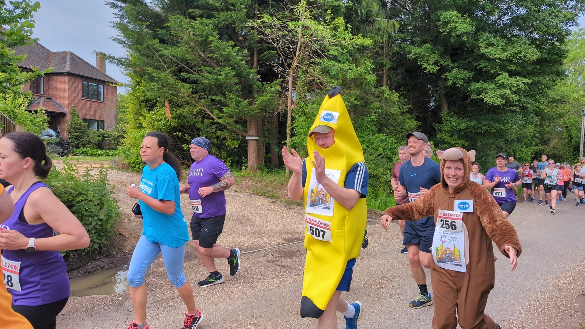 A group of people are running in a race and one of them is wearing a banana costume.